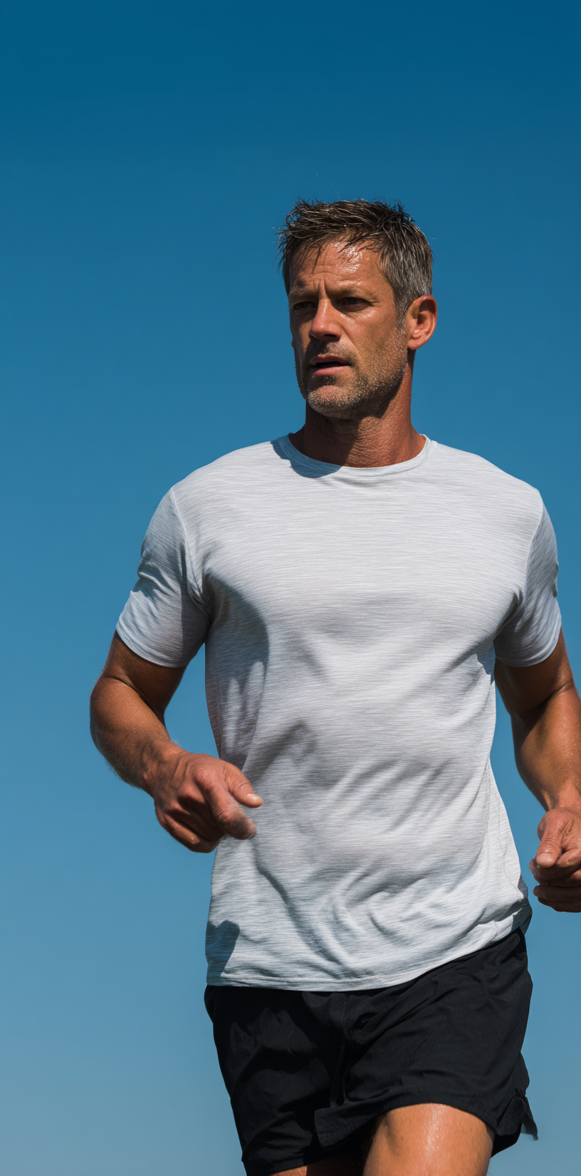 Man running under a clear blue sky