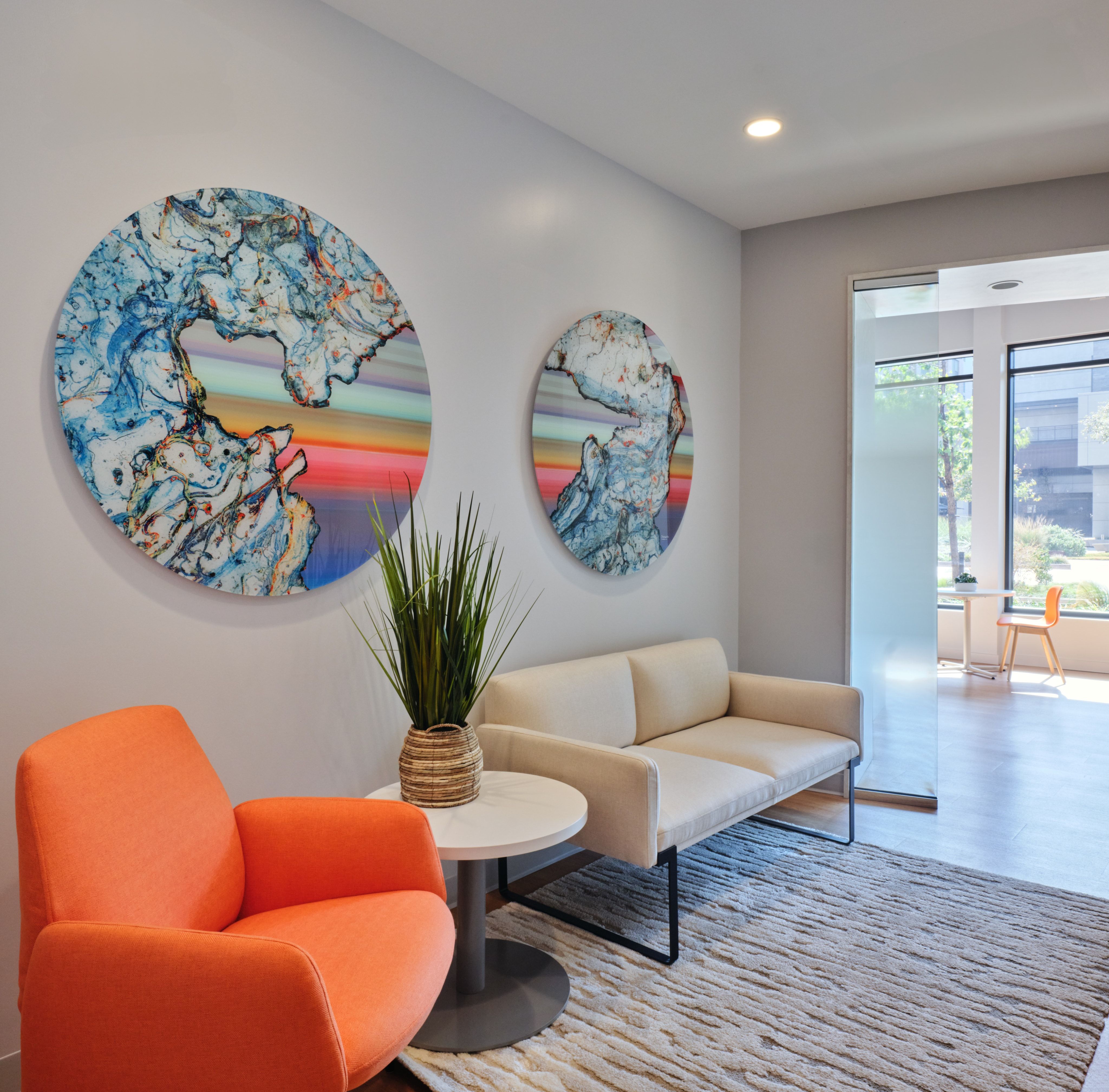 Waiting area with circular blue artworks and a coral accent chair