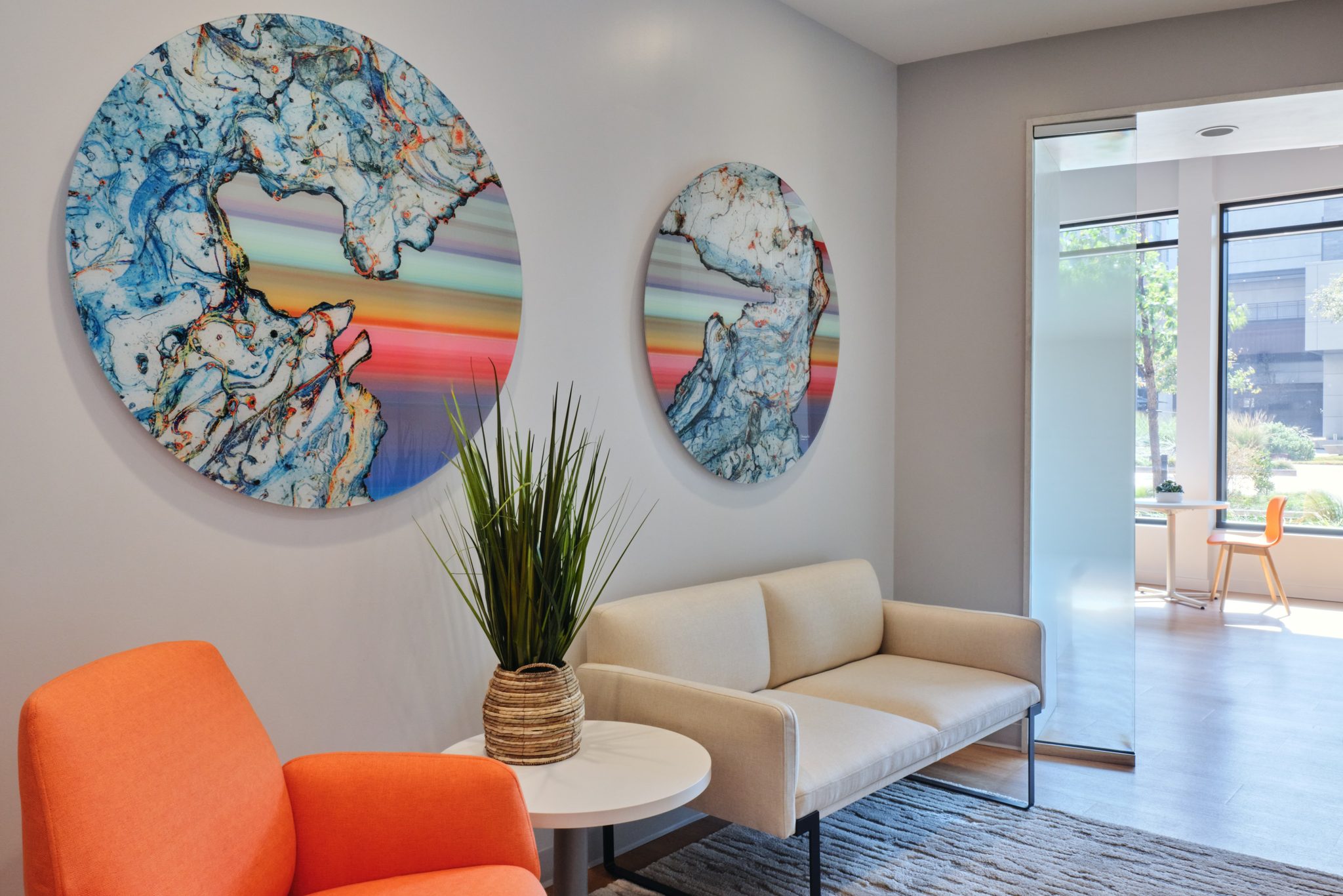 Waiting area with circular blue artworks and a coral accent chair