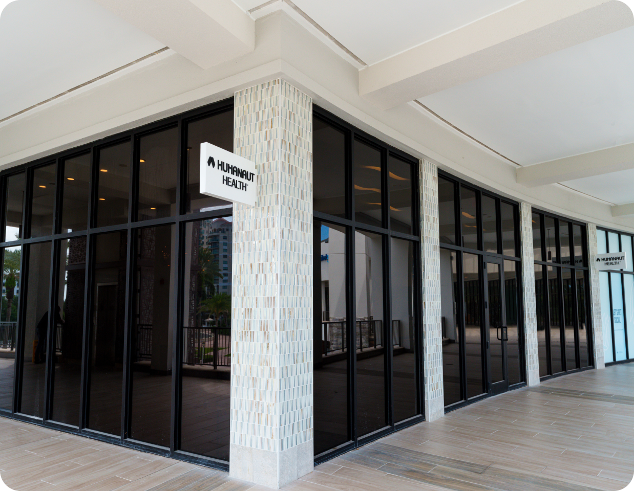 Exterior of a Humanaut Health clinic — a glass-walled building with brand signage