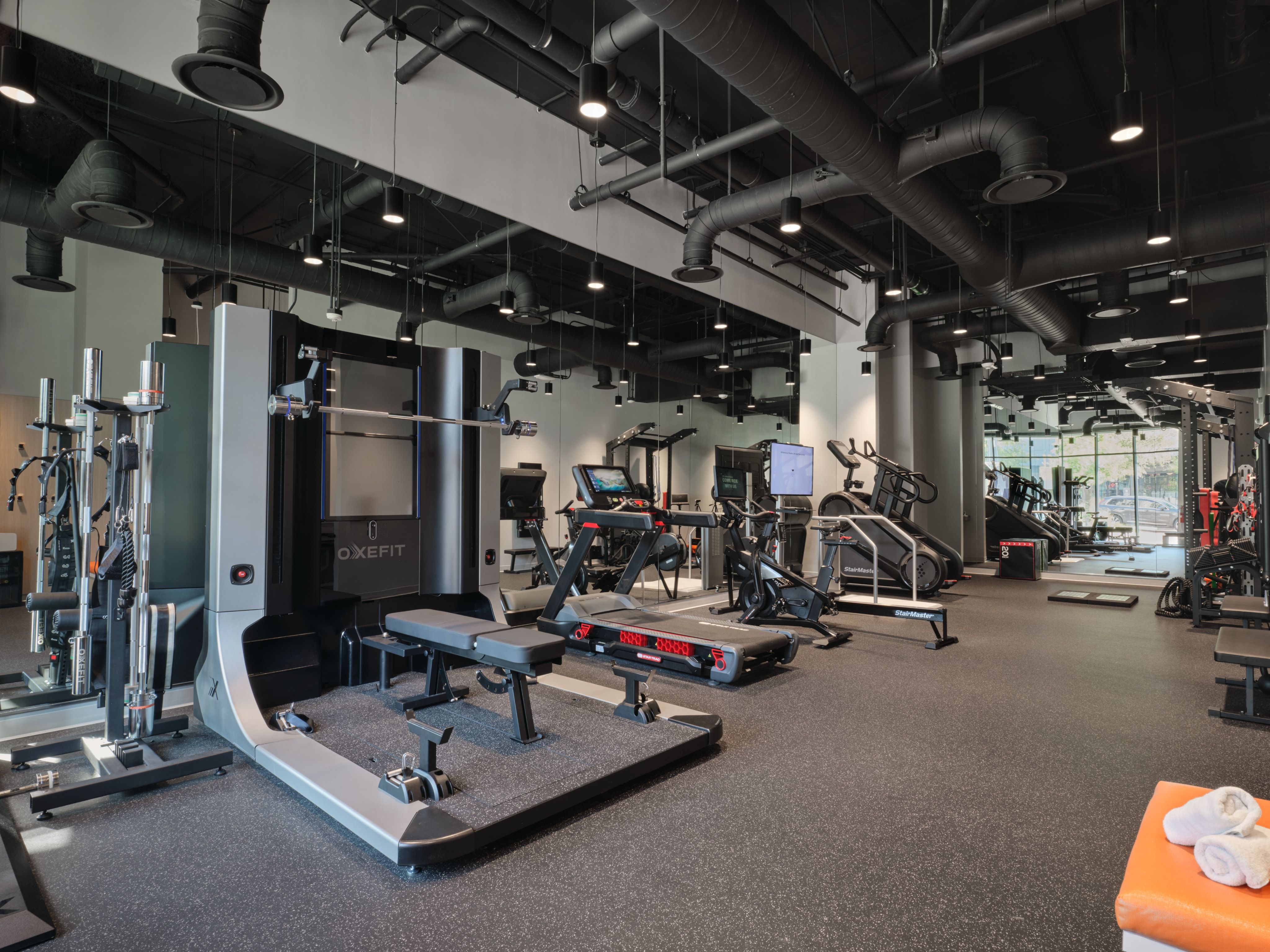 Member training gym with strength equipment and exposed industrial ceiling