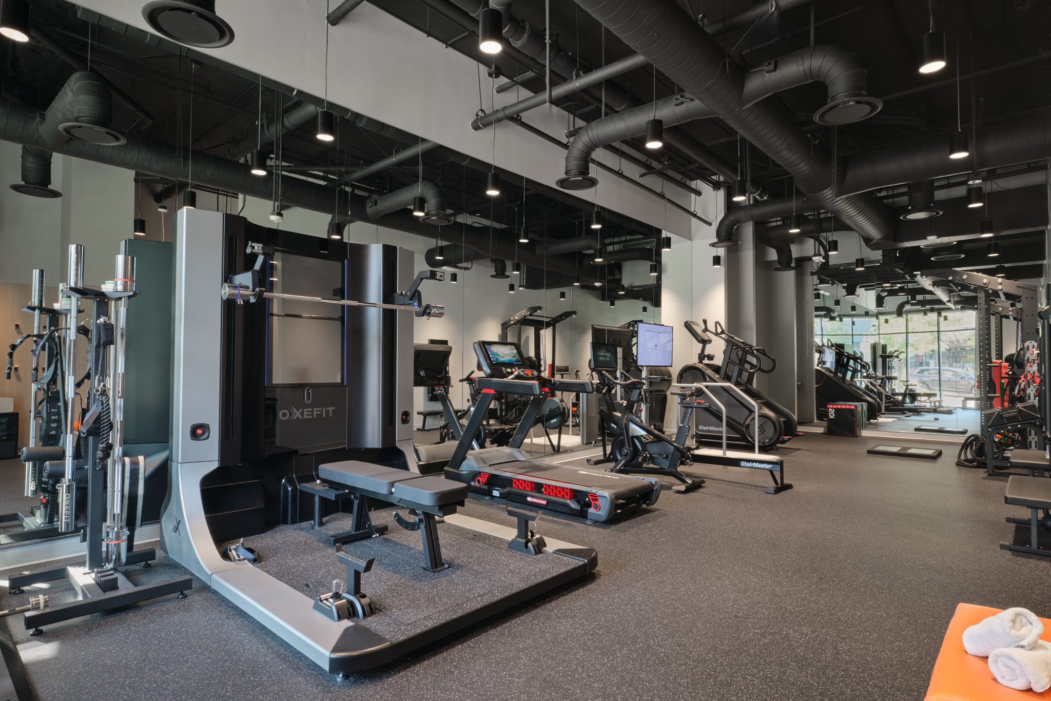 Member training gym with strength equipment and exposed industrial ceiling