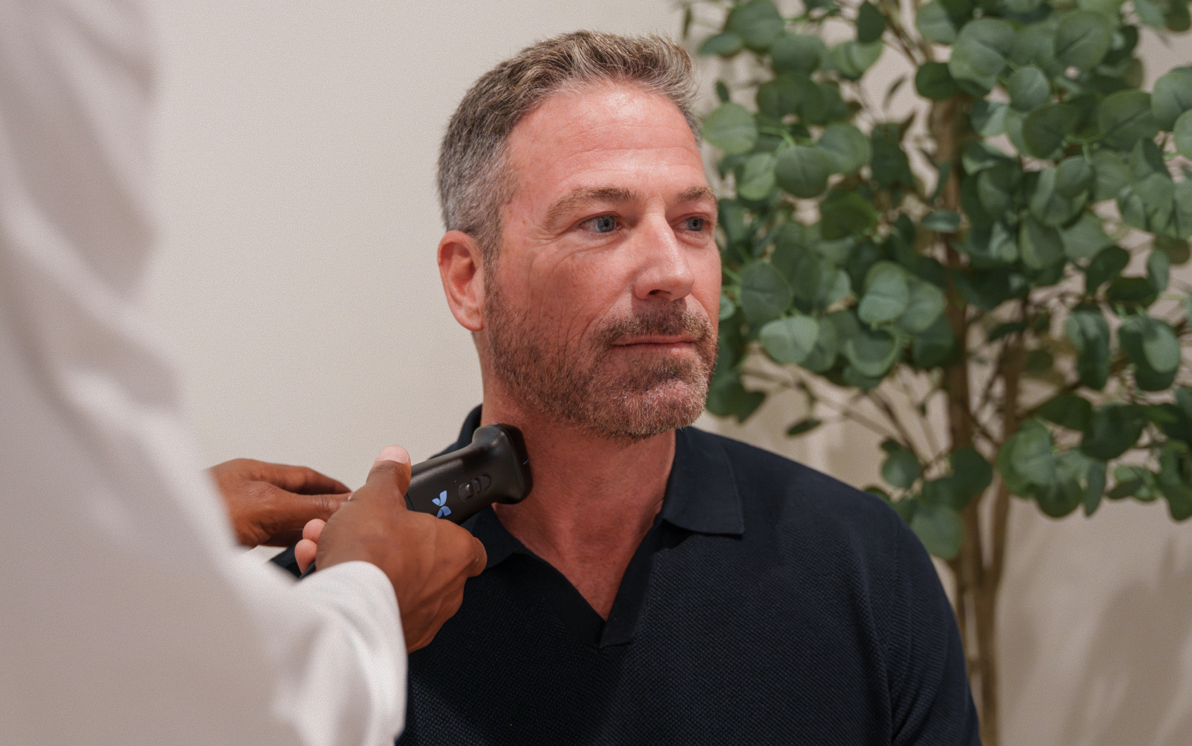 Patient seated as a provider performs a CIMT carotid intima-media thickness ultrasound