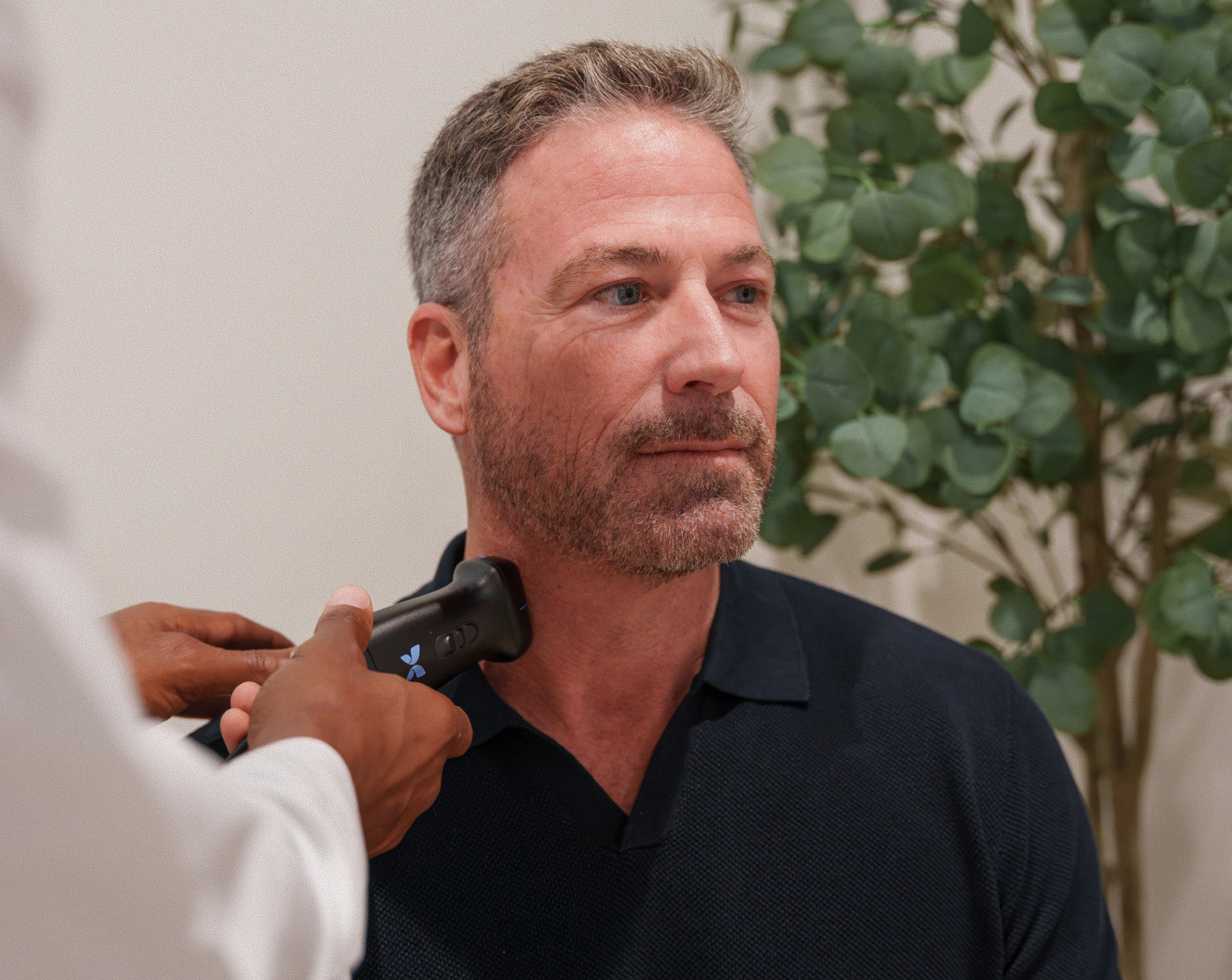 Patient seated as a provider performs a CIMT carotid intima-media thickness ultrasound