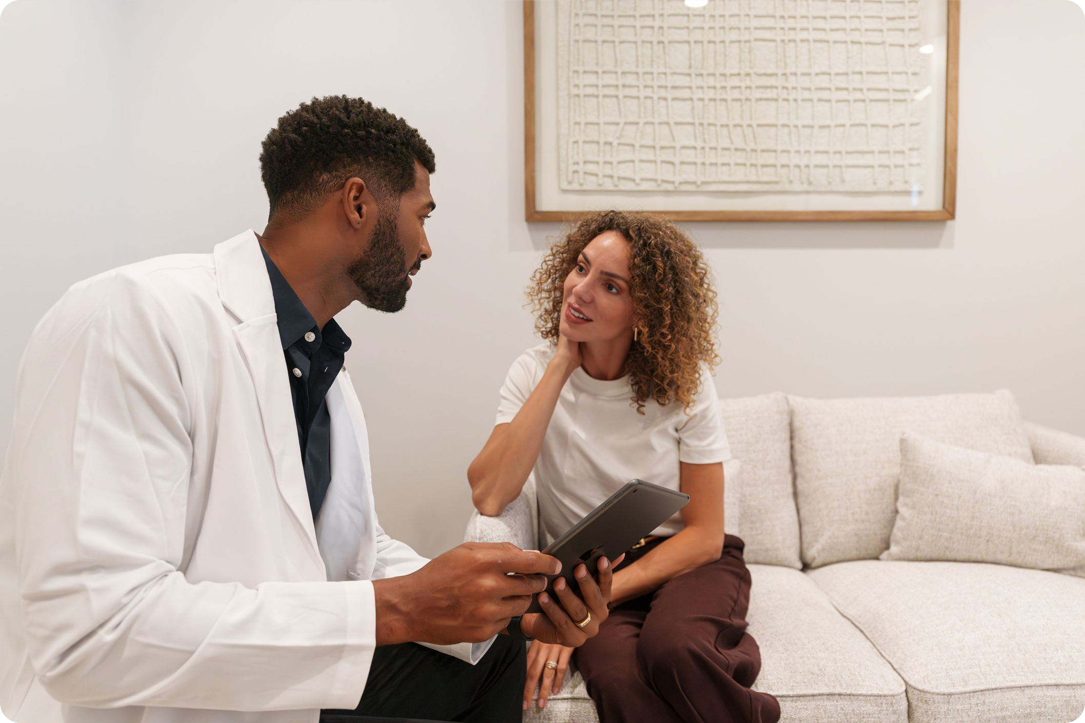 Clinician reviewing a tablet with a member during a consultation