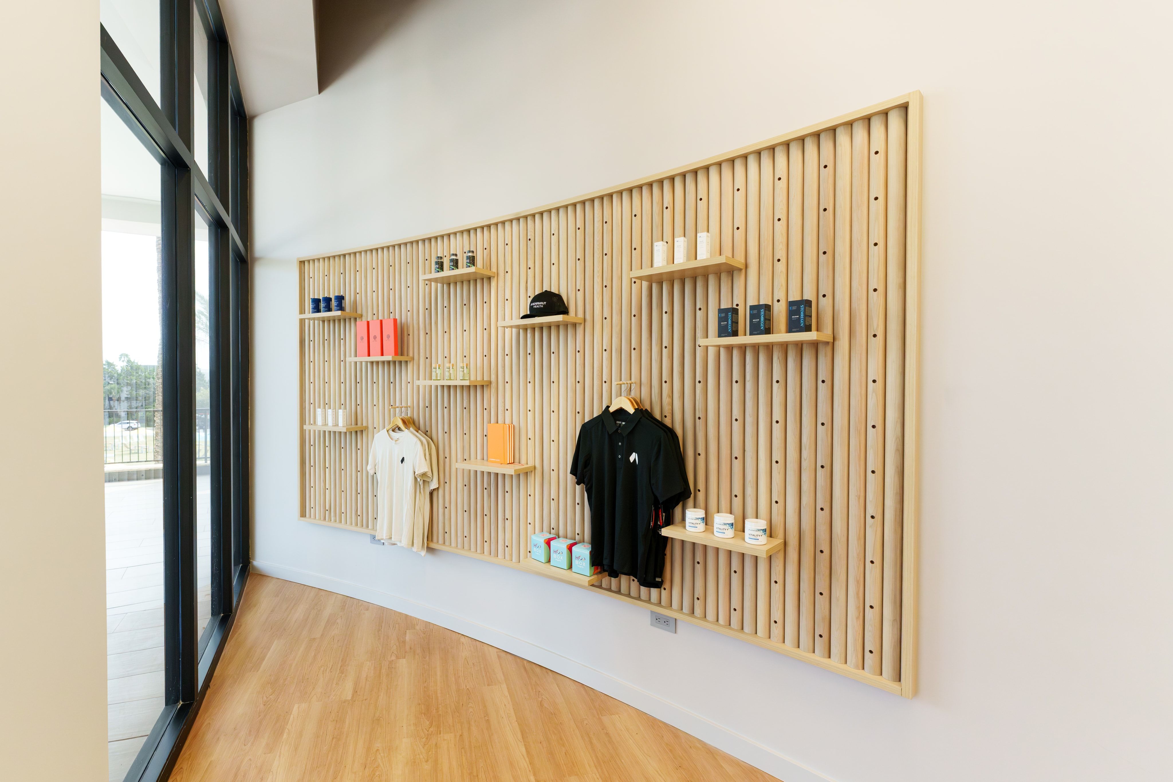 Slatted-wood product wall displaying branded apparel and supplements