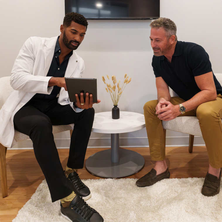 Clinician reviewing test results on a tablet with a male patient