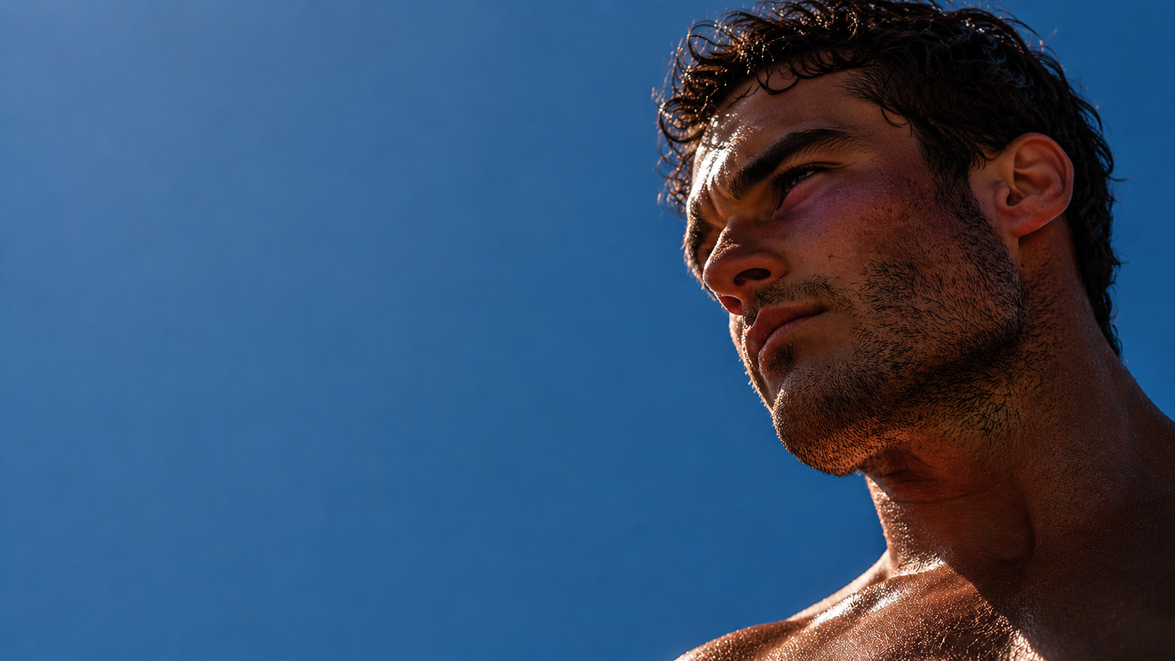 Man in profile lit by cinematic blue light, gazing upward