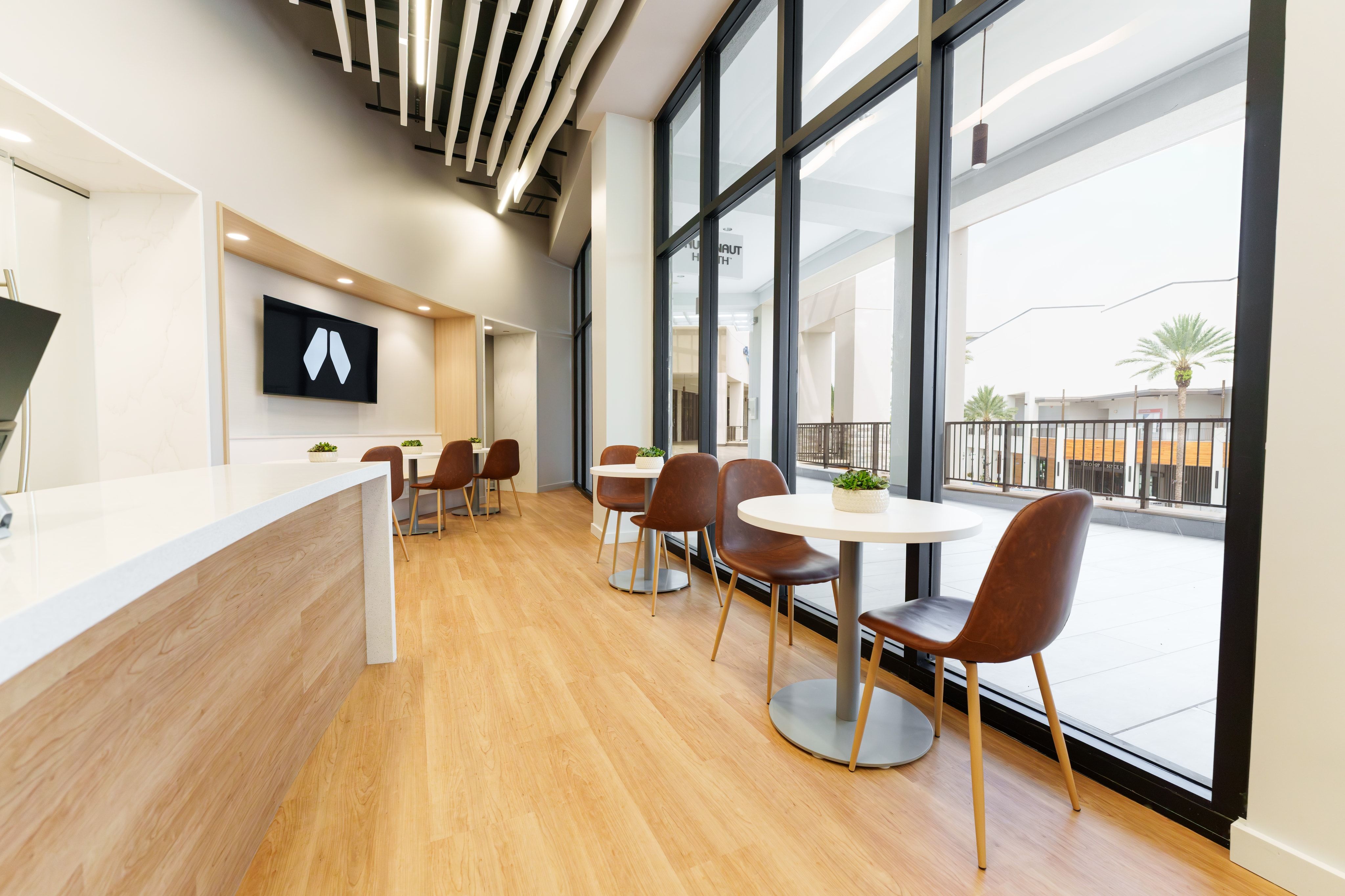 Member cafe area with leather chairs beside floor-to-ceiling windows