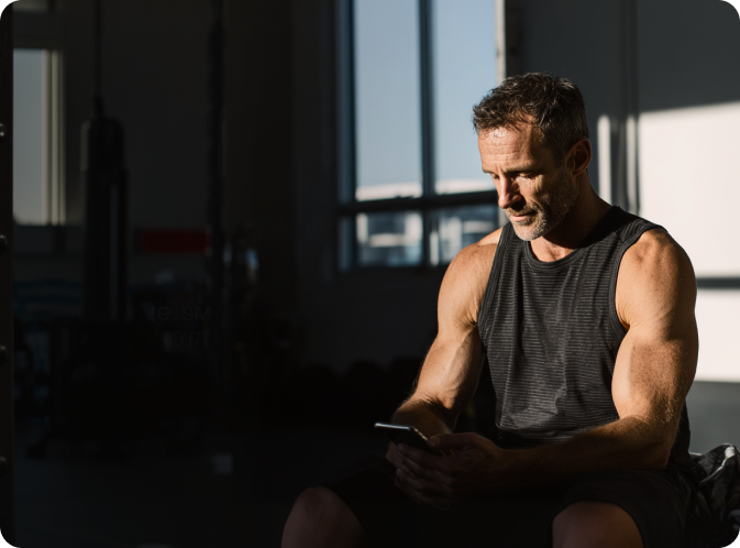 Fit middle-aged man seated after a personalized strength session