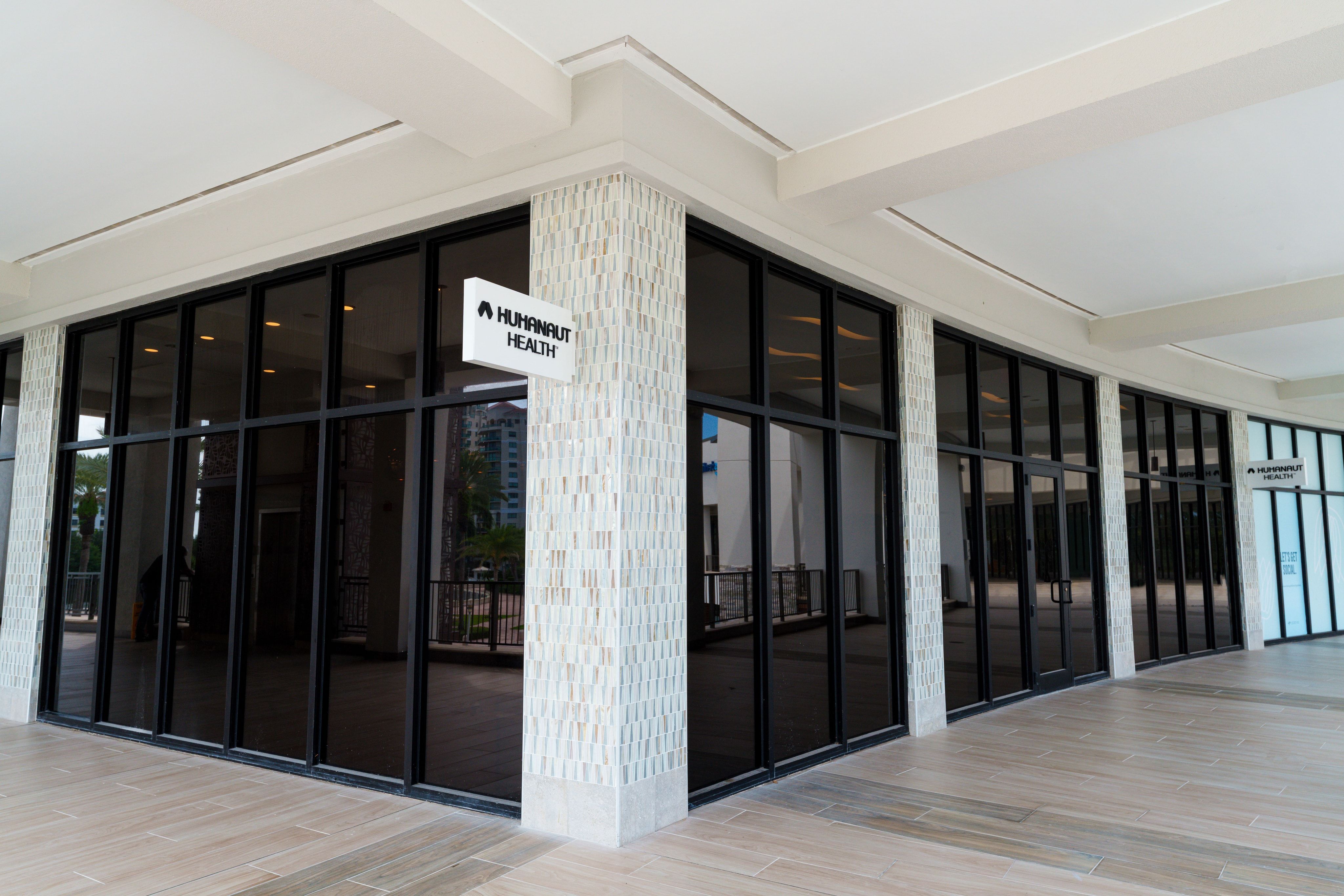 Storefront entrance with floor-to-ceiling glass and a Humanaut Health logo panel