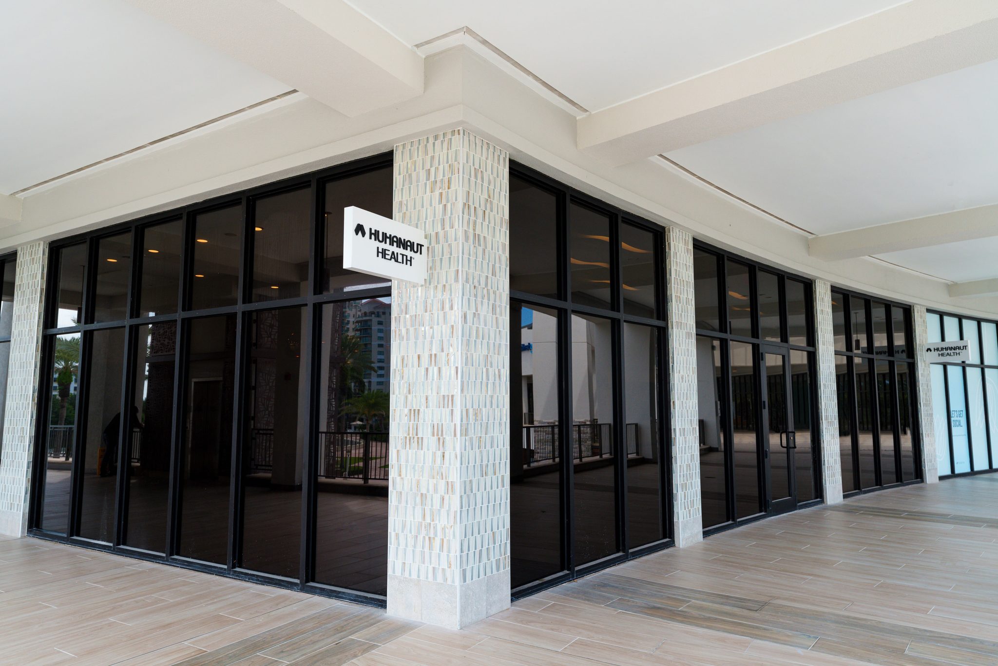 Storefront entrance with floor-to-ceiling glass and a Humanaut Health logo panel