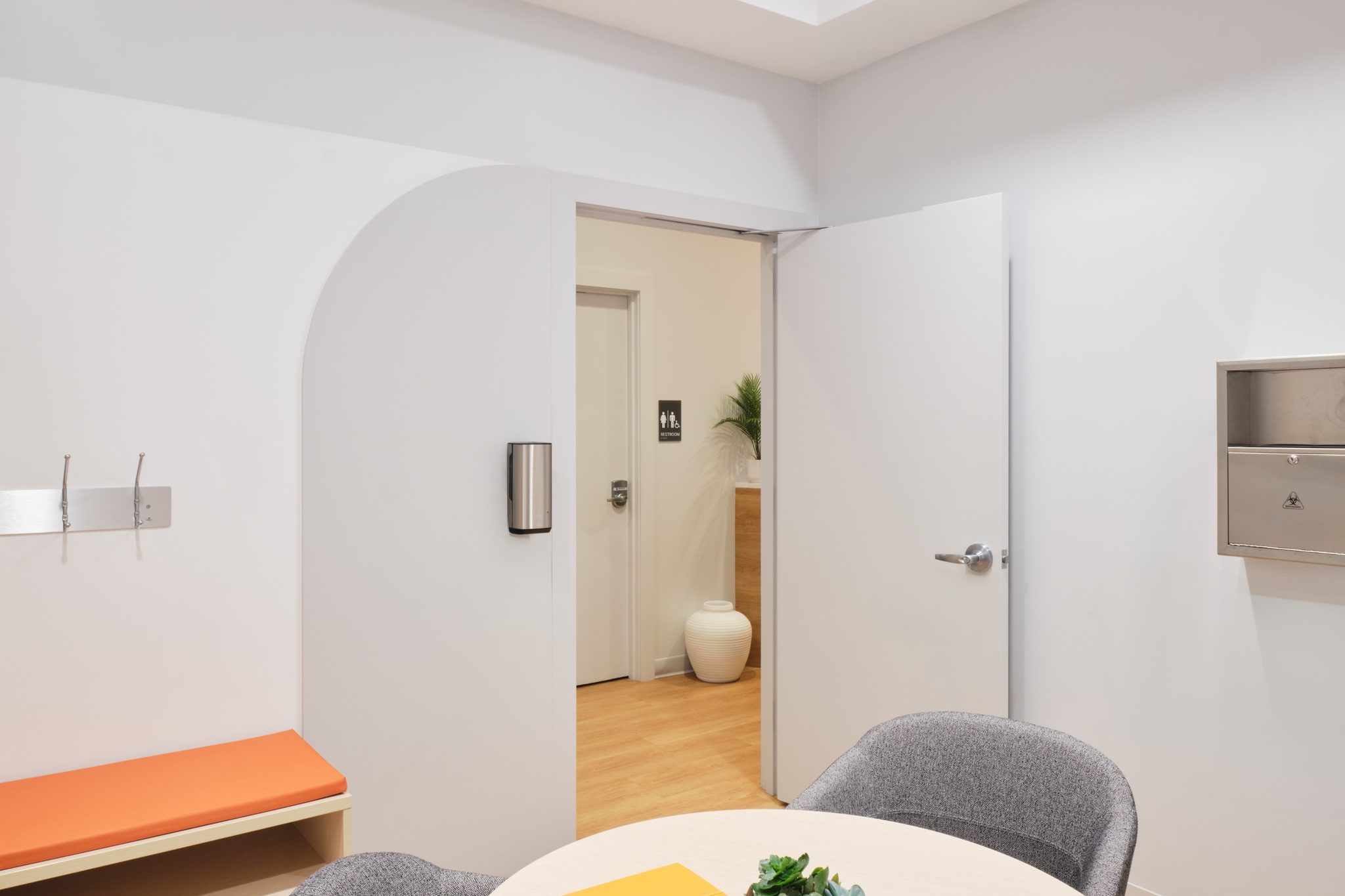 Consult room with round table and soft sculptural ceiling tiles