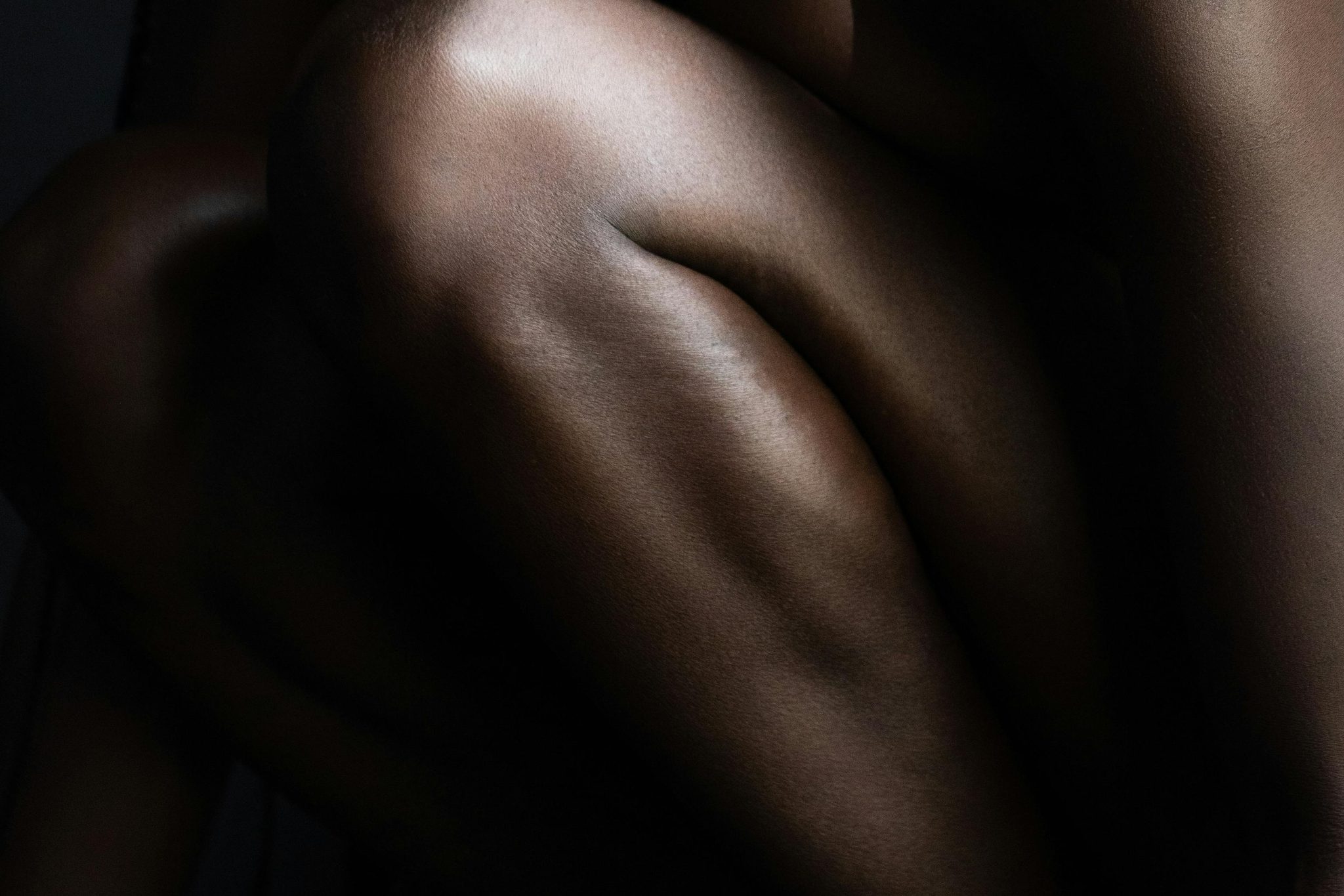 Close-up of folded legs in dramatic low light