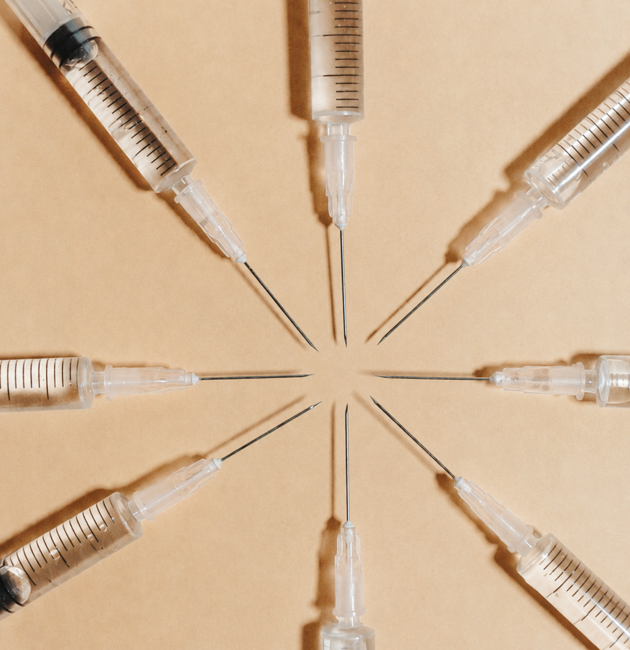 Overhead arrangement of glass syringes arrayed in a sunburst pattern