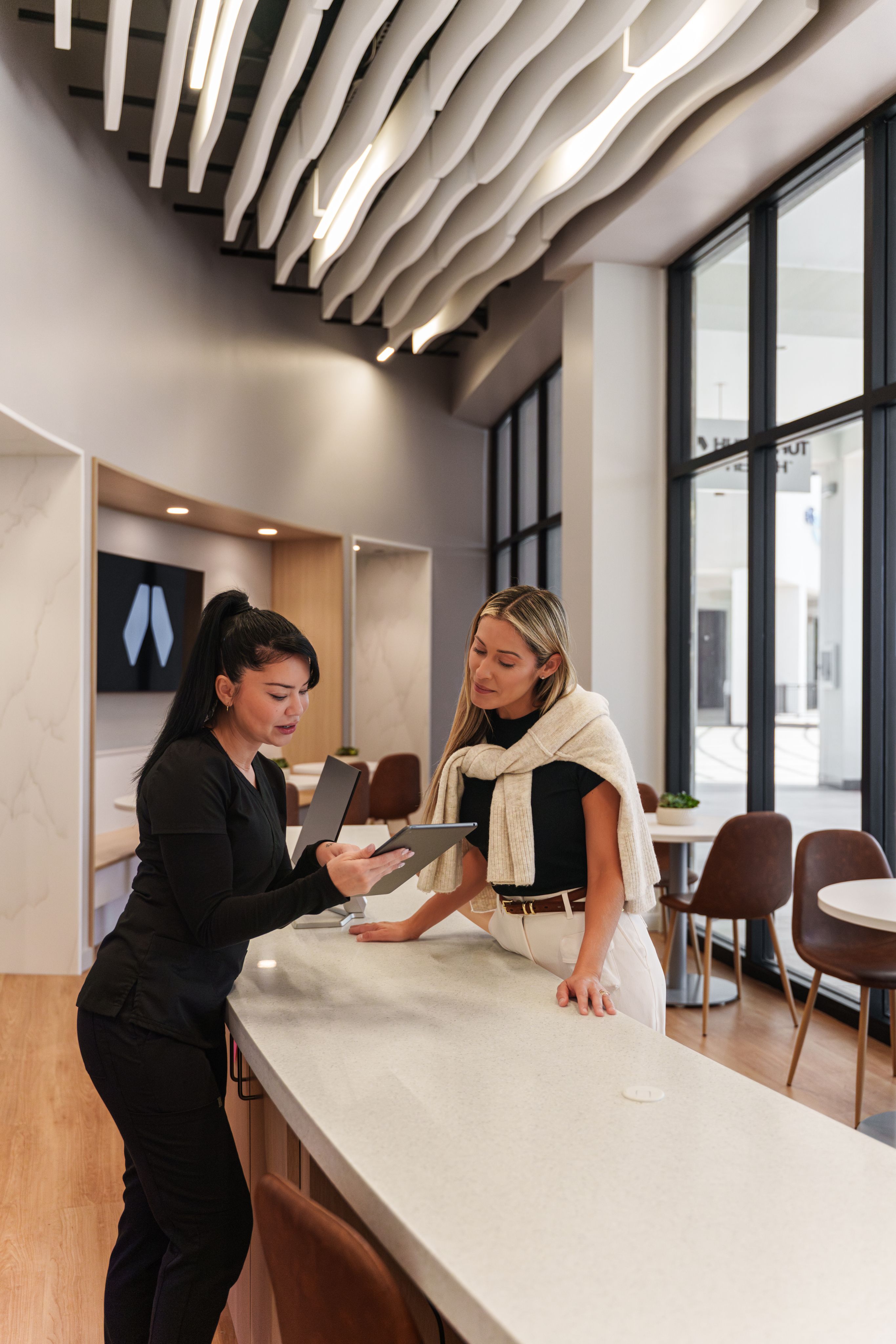 Provider and patient reviewing biomarker results on a tablet at a clinic counter