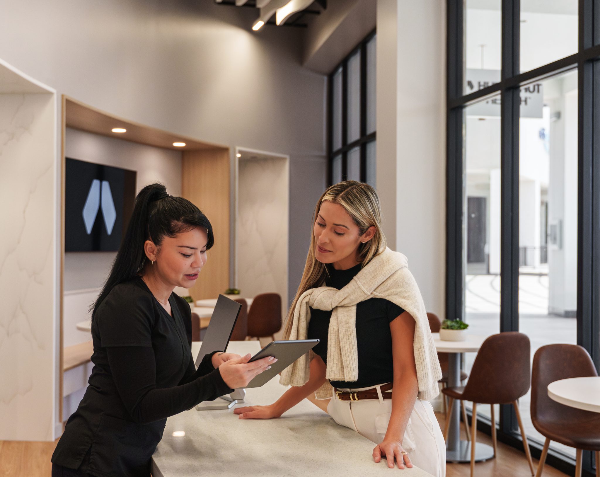 Provider and patient reviewing biomarker results on a tablet at a clinic counter