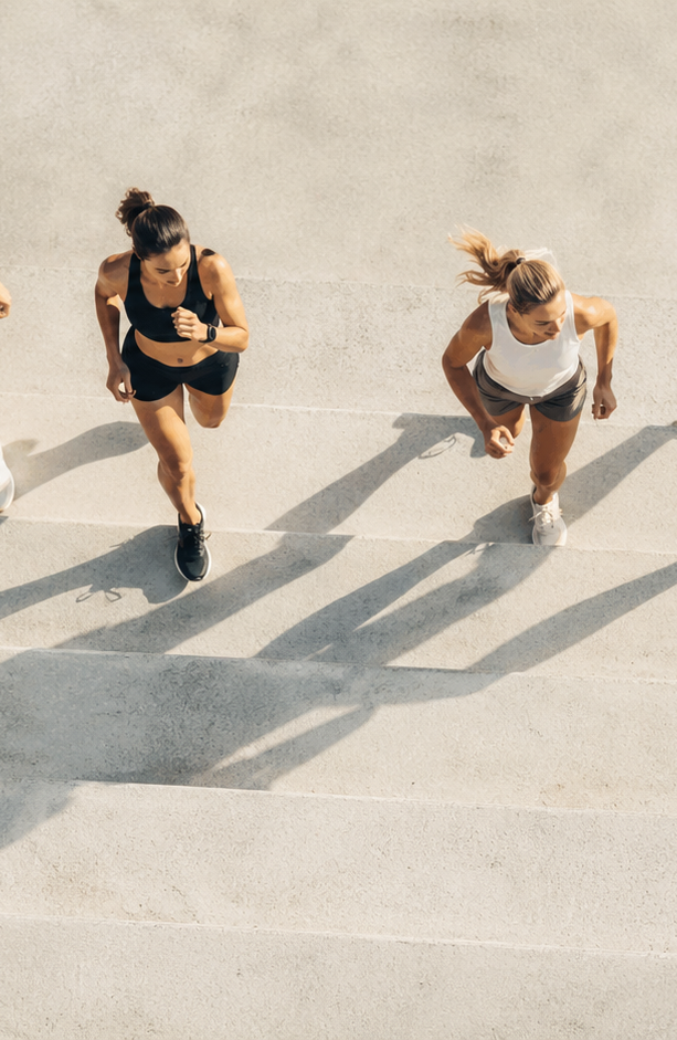 Aerial view of four runners on concrete steps casting long shadows
