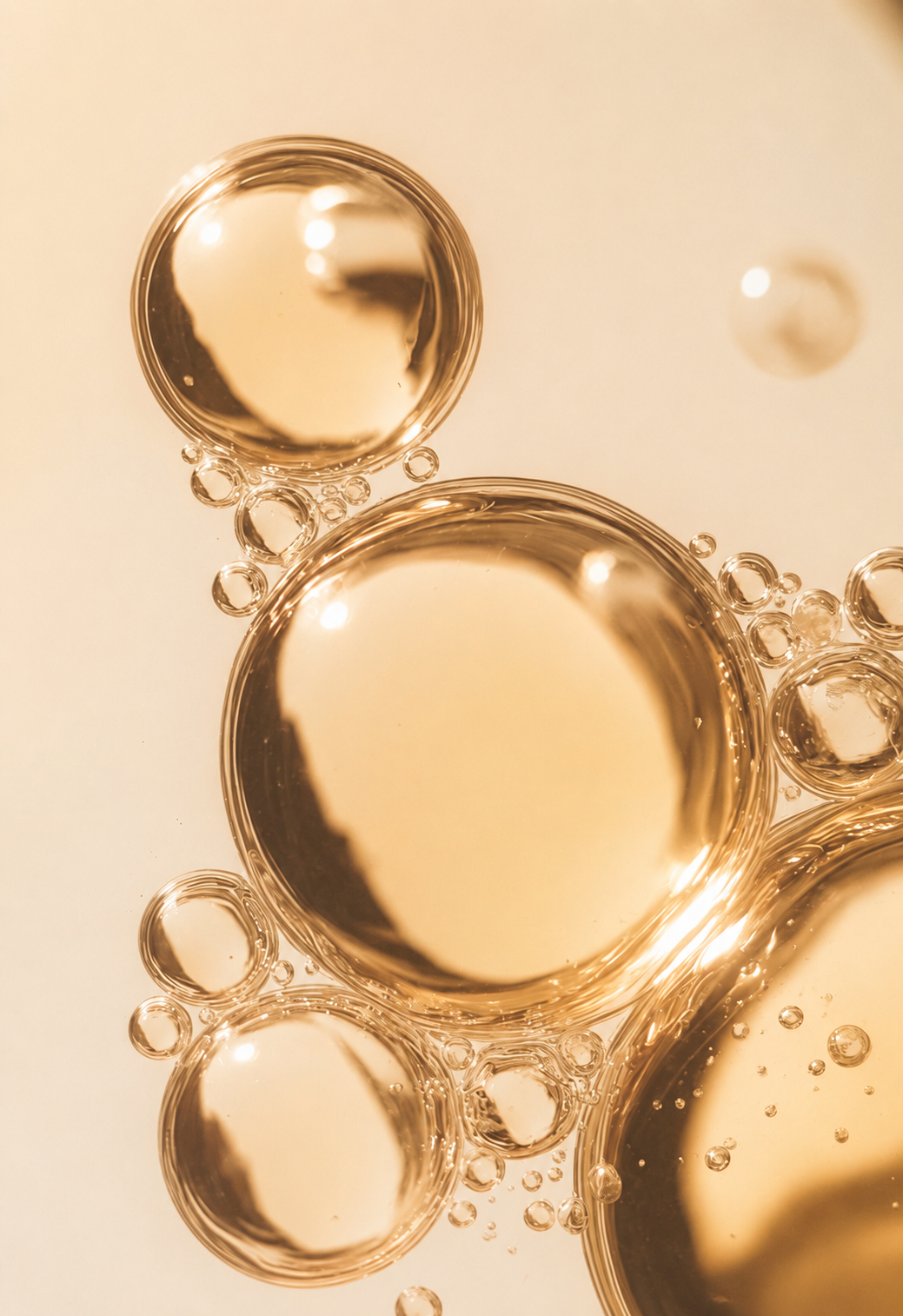 Macro shot of a luminous golden droplet suspended in a glass surface